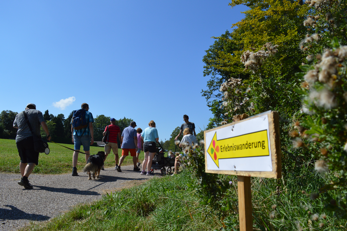 Personen und ein Schild in der Natur