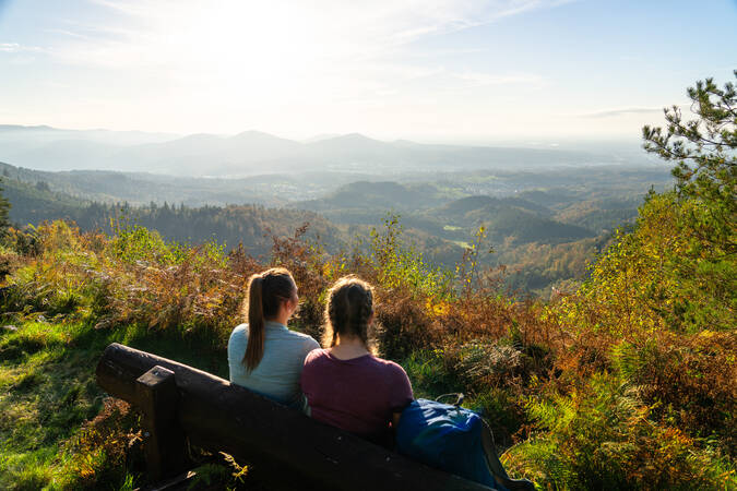 Aussicht im Hintergrund, zwei Frauen sitzend auf einer Bank